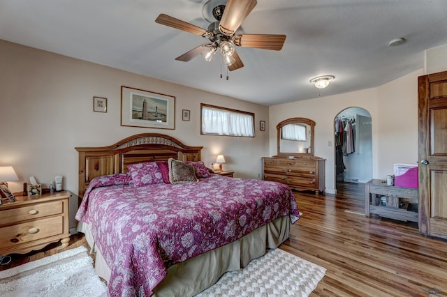 2204 Cruz Dr, Rapid City, SD 57702 - bedroom with arched walkways, a ceiling fan, and wood finished floors