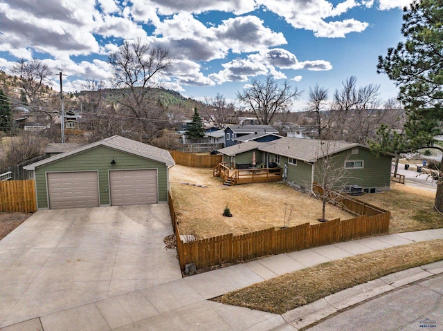 2204 Cruz Dr, Rapid City, SD 57702 - view of front facade with an outbuilding, driveway, a garage, a fenced front yard, and a deck