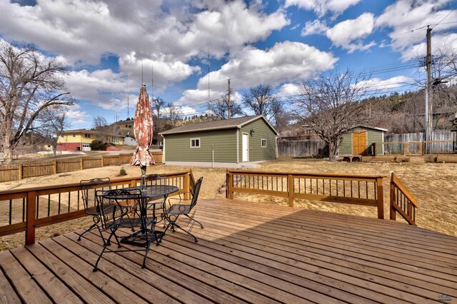 2204 Cruz Dr, Rapid City, SD 57702 - deck with outdoor dining space, an outdoor structure, and a fenced backyard