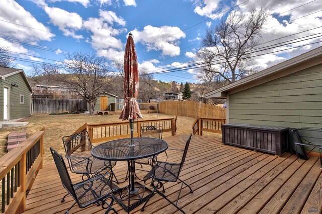 2204 Cruz Dr, Rapid City, SD 57702 - wooden deck with a storage unit, an outbuilding, a fenced backyard, and outdoor dining space