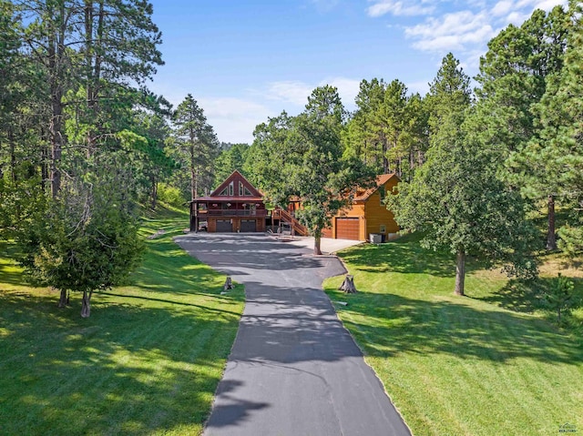 view of home's community with aphalt driveway, a yard, and a garage