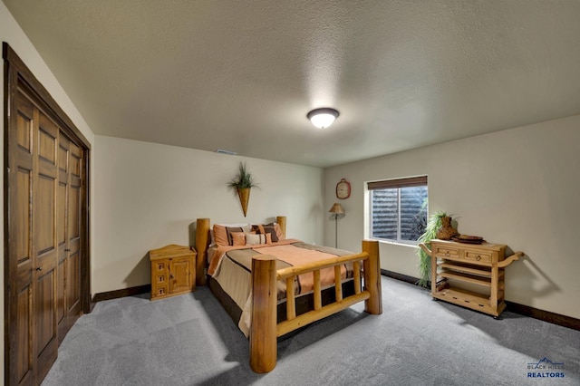 bedroom featuring a closet, a textured ceiling, baseboards, and carpet