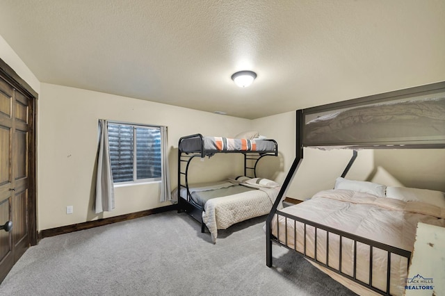 carpeted bedroom with a closet, baseboards, and a textured ceiling
