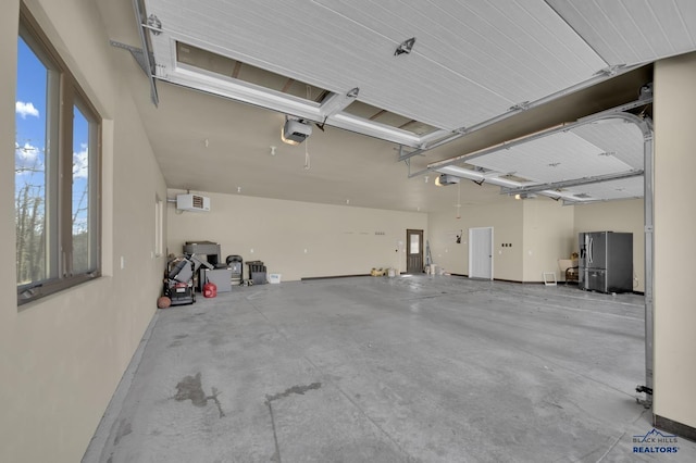 garage featuring a garage door opener, stainless steel refrigerator with ice dispenser, and a wall mounted AC