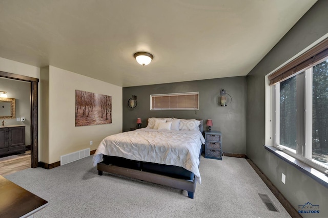 bedroom with visible vents, baseboards, and light colored carpet