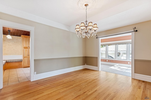 1120 W Blvd, Rapid City, SD 57701 - spare room featuring an inviting chandelier, baseboards, and light wood-style floors