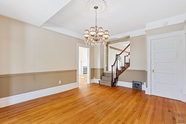 1120 W Blvd, Rapid City, SD 57701 - unfurnished room featuring stairway, a notable chandelier, light wood-style floors, and baseboards