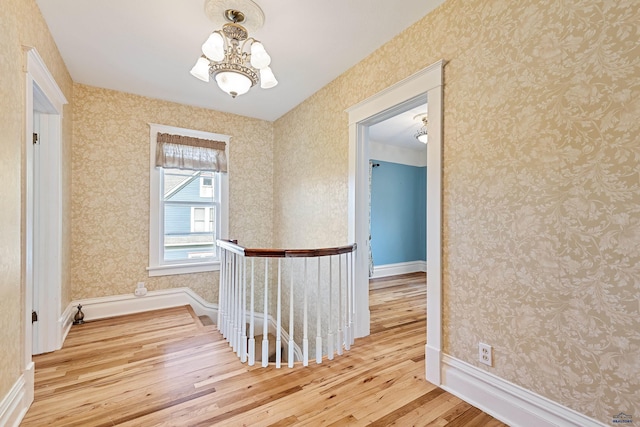 1120 W Blvd, Rapid City, SD 57701 - corridor featuring a notable chandelier, an upstairs landing, hardwood / wood-style flooring, and wallpapered walls