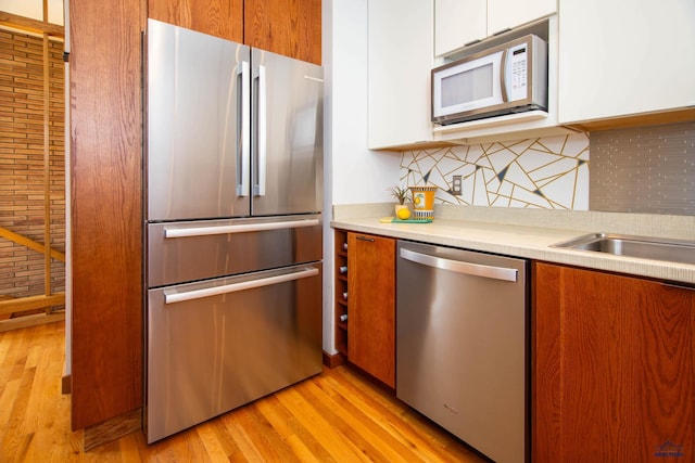 1515 Forest Dr, Rapid City, SD 57701 - kitchen with tasteful backsplash, light wood-type flooring, light countertops, stainless steel appliances, and white cabinetry