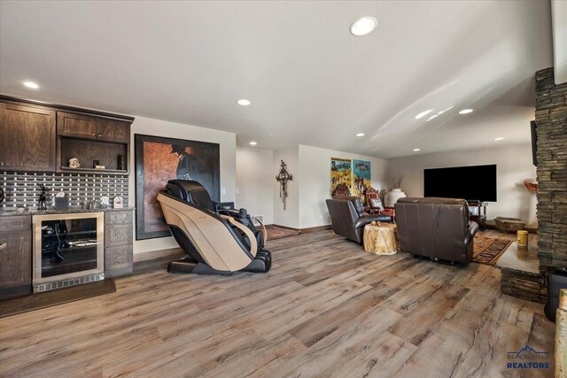 living area featuring recessed lighting, light wood-type flooring, wine cooler, and a dry bar