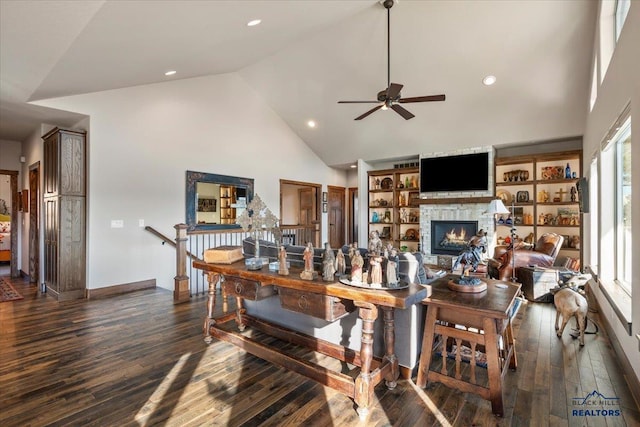 dining room featuring dark wood-style floors, high vaulted ceiling, recessed lighting, ceiling fan, and a stone fireplace