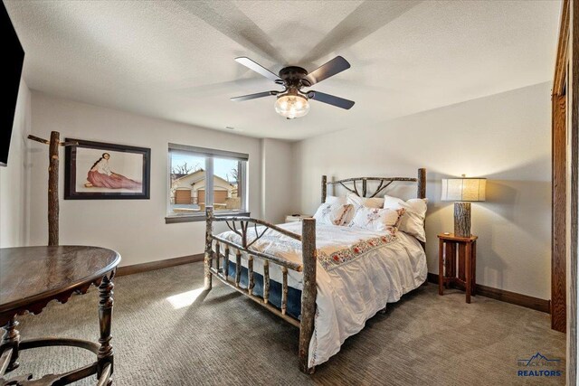 carpeted bedroom with a textured ceiling, baseboards, and a ceiling fan