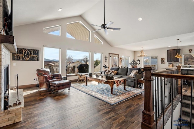 living area featuring high vaulted ceiling, ceiling fan with notable chandelier, dark wood-style floors, recessed lighting, and baseboards