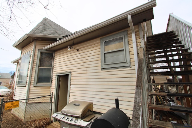 920 Haines Ave, Rapid City, SD 57701 - rear view of house with a shingled roof, stairs, and fence