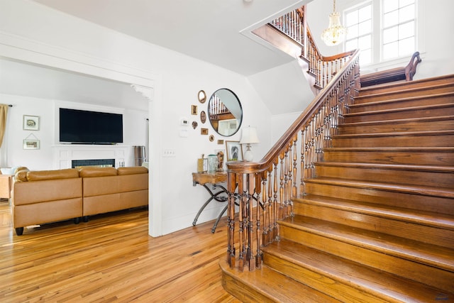 1000 W Blvd, Rapid City, SD 57701 - stairway with a chandelier, wood finished floors, and a fireplace