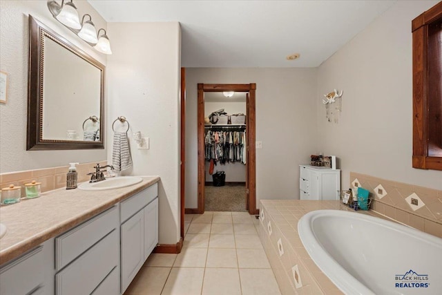 19329 US Highway 85, Belle Fourche, SD 57717 - full bathroom with tile patterned floors, vanity, a walk in closet, a bath, and baseboards