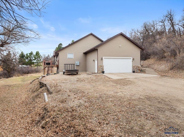 19329 US Highway 85, Belle Fourche, SD 57717 - view of home's exterior with a deck, an attached garage, and dirt driveway