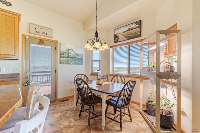 dining room featuring an inviting chandelier, baseboards, lofted ceiling, and visible vents