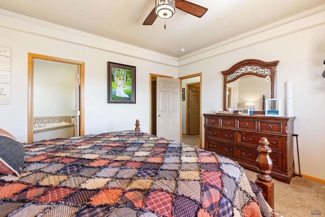 carpeted bedroom featuring baseboards, ensuite bath, and ceiling fan