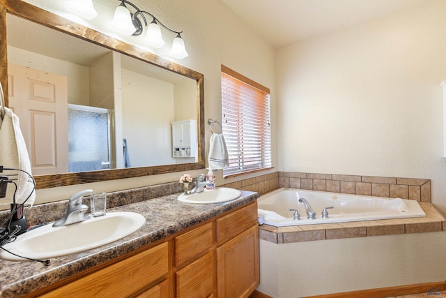 full bathroom featuring double vanity, a sink, and a garden tub