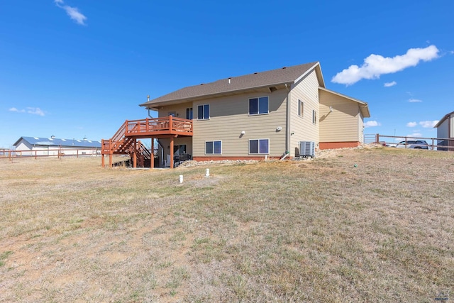 rear view of house featuring stairs, cooling unit, a deck, and a lawn