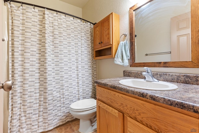 bathroom featuring toilet, vanity, and tile patterned flooring