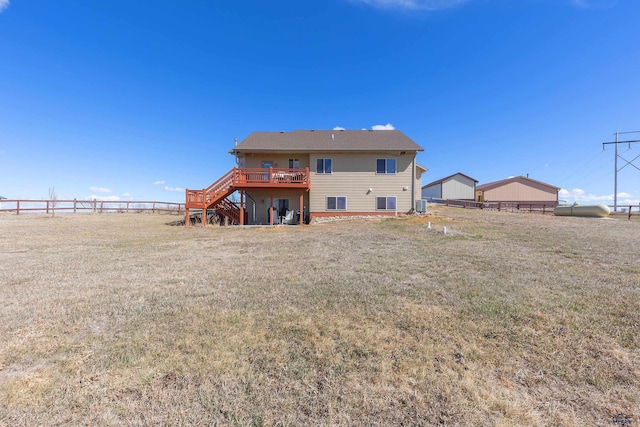 back of property featuring a lawn, fence, stairs, and a wooden deck