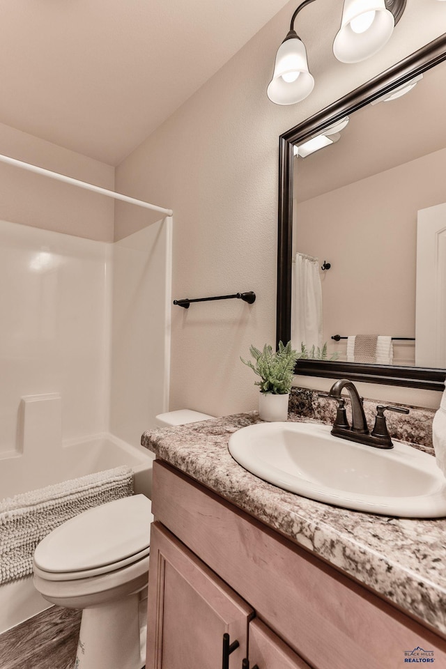 bathroom with toilet, shower / tub combo with curtain, vanity, and wood finished floors
