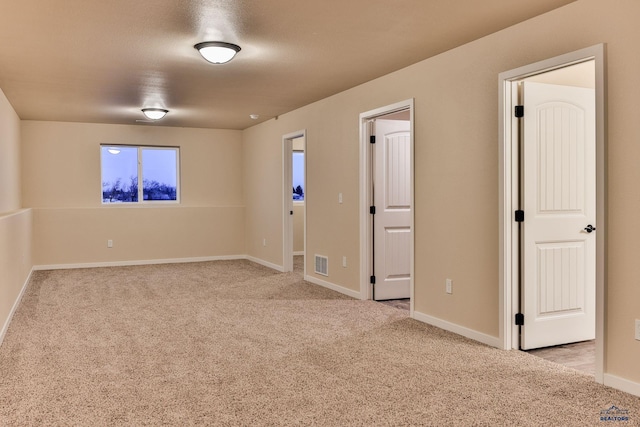 unfurnished room featuring light colored carpet, baseboards, and visible vents