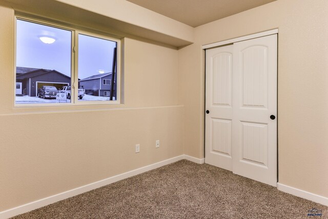 unfurnished bedroom with a closet, baseboards, and carpet floors