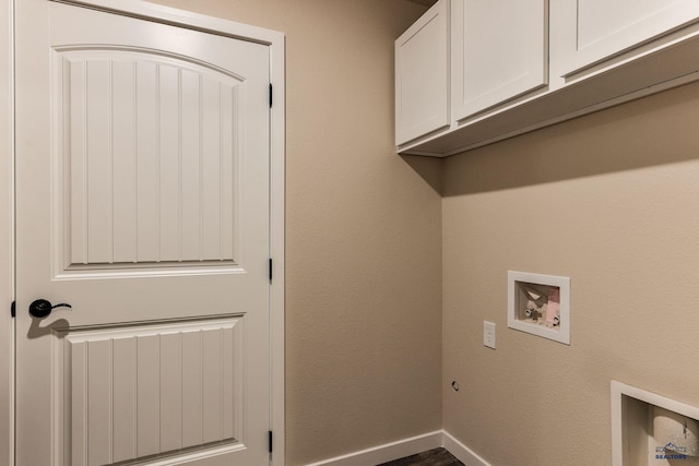 washroom with cabinet space, baseboards, and washer hookup