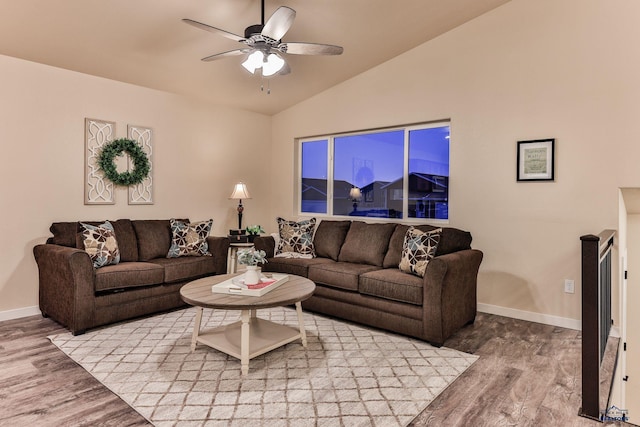 living area with wood finished floors, ceiling fan, baseboards, and lofted ceiling