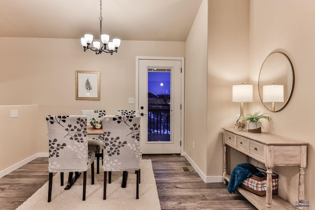 dining space with a notable chandelier, dark wood finished floors, and baseboards