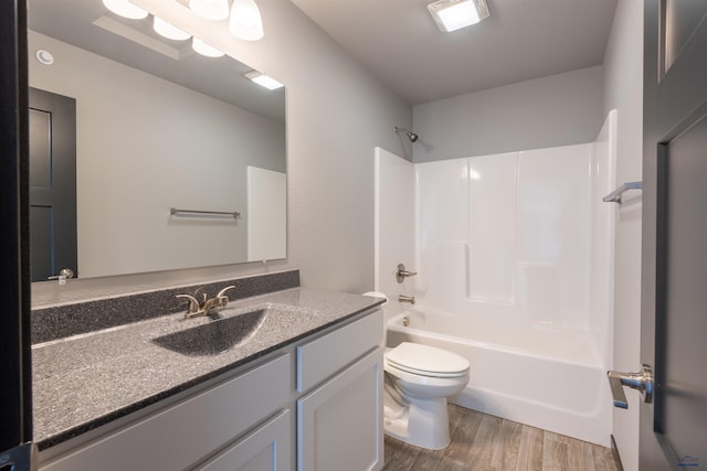 full bathroom featuring toilet,  shower combination, wood finished floors, and vanity