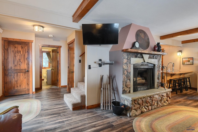 living area featuring stairway, a fireplace, wood finished floors, baseboards, and beamed ceiling