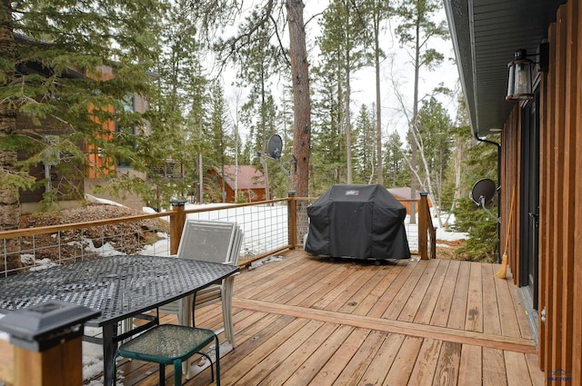 wooden deck with outdoor dining area and area for grilling