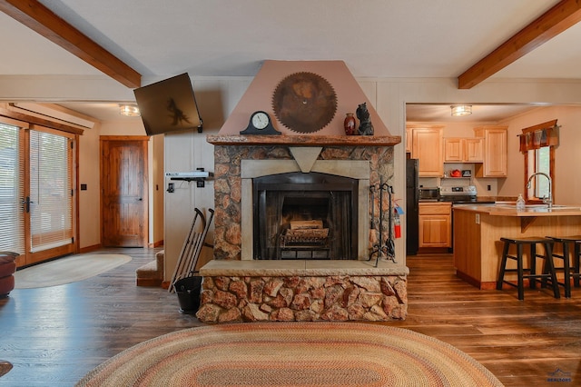 living room with baseboards, a fireplace, beam ceiling, and dark wood finished floors