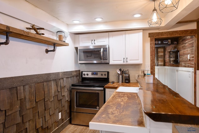 kitchen featuring open shelves, light wood-type flooring, backsplash, white cabinets, and appliances with stainless steel finishes