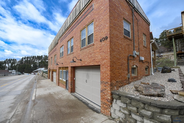 view of building exterior featuring a garage and concrete driveway