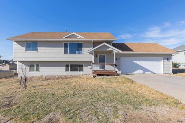 split level home featuring driveway, an attached garage, and a front yard
