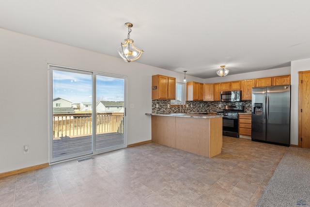kitchen featuring appliances with stainless steel finishes, a peninsula, hanging light fixtures, visible vents, and decorative backsplash