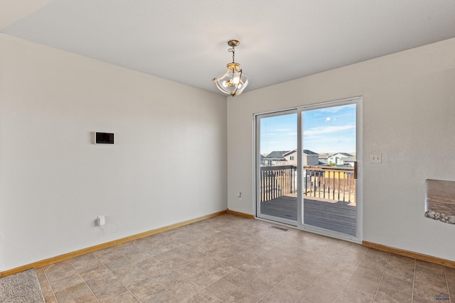 unfurnished room with baseboards, visible vents, and a notable chandelier