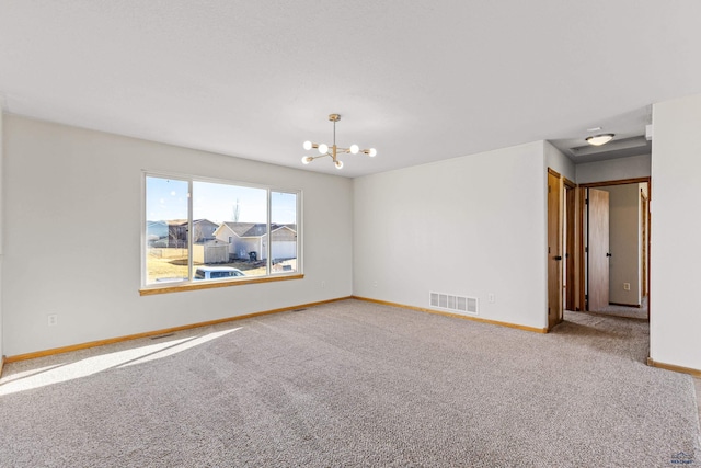empty room with baseboards, carpet flooring, visible vents, and a chandelier