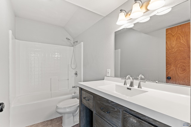 full bathroom featuring washtub / shower combination, toilet, tile patterned floors, vanity, and vaulted ceiling