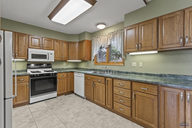 2506 Junction Dr, Rapid City, SD 57702 - kitchen featuring dark countertops, brown cabinets, and white appliances