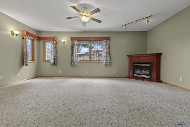 2506 Junction Dr, Rapid City, SD 57702 - unfurnished living room with baseboards, a ceiling fan, a glass covered fireplace, and carpet