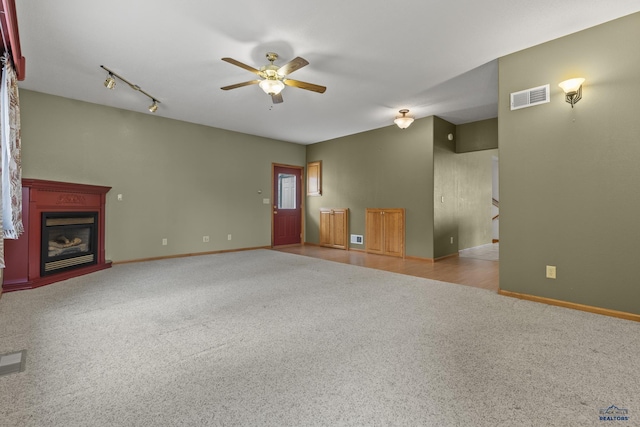2506 Junction Dr, Rapid City, SD 57702 - unfurnished living room featuring carpet flooring, baseboards, ceiling fan, visible vents, and a glass covered fireplace