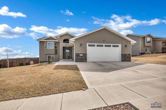 4400 Beringer Dr, Rapid City, SD 57703 - view of front of house featuring driveway, a garage, fence, and a front lawn
