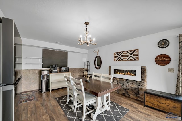 4400 Beringer Dr, Rapid City, SD 57703 - dining space with dark wood-style floors, a notable chandelier, visible vents, and a glass covered fireplace
