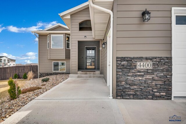 4400 Beringer Dr, Rapid City, SD 57703 - view of exterior entry featuring stone siding and fence